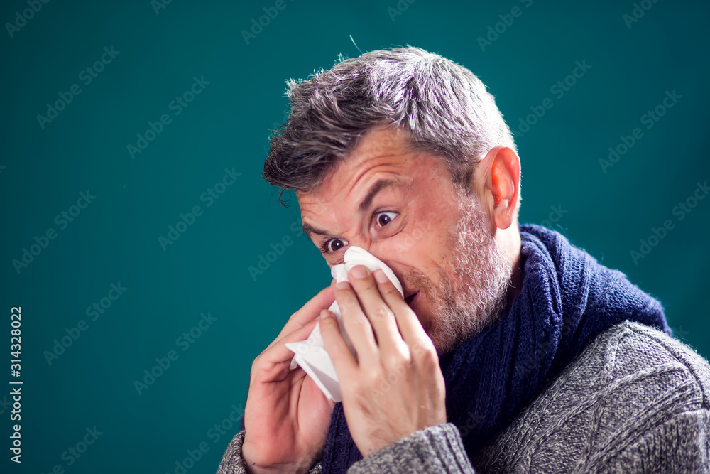 Man got the flu, blowing nose into napkin. People, healthcare and medicine concept Man got the flu, blowing nose into napkin. People, healthcare and medicine concept