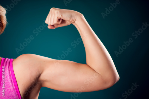 Woman showing triceps and bicep. People, fitness and health concept photo