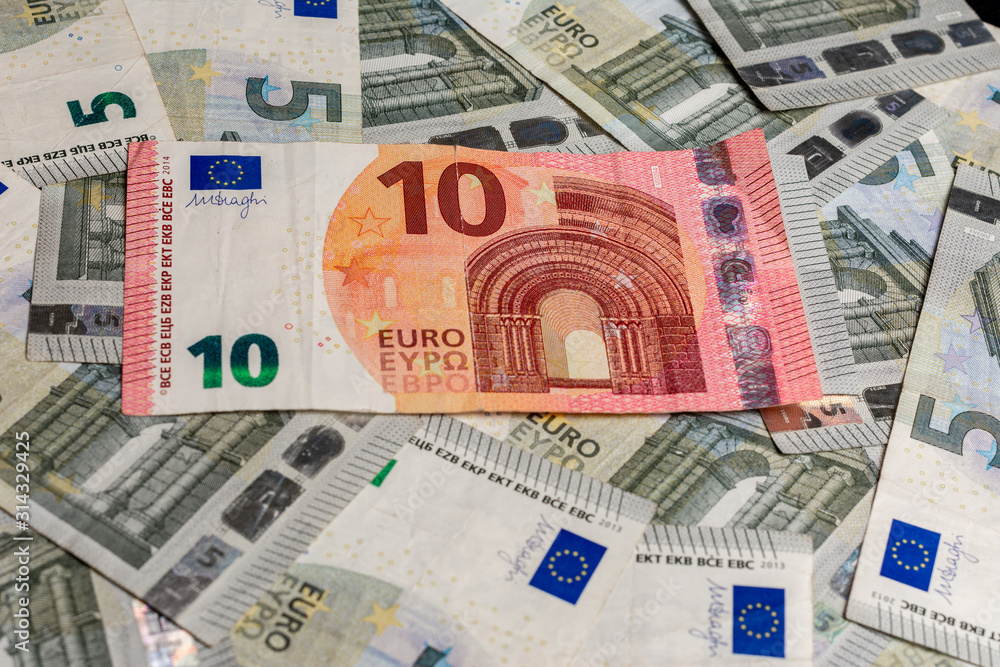 Euro banknotes, texture from 5 and 10 euros, ten euros outweigh five euros. Euro banknotes, texture from 5 and 10 euros, ten euros outweigh five euros.