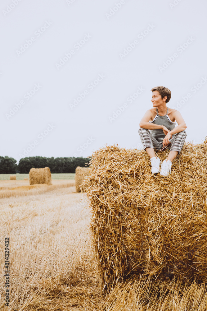 lifestyle girl sitting round haystack field harvest lifestyle girl sitting round haystack field harvest