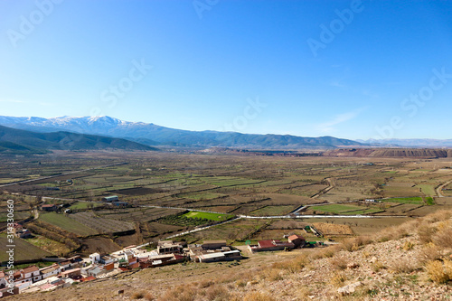 landscape with valley full of fields in sierra nevada mountains and blue sky