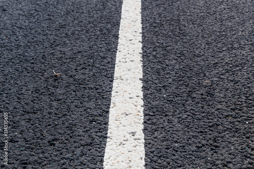 White solid line. Road marking on an asphalt road