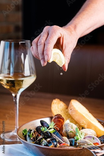 Fototapeta Naklejka Na Ścianę i Meble -  Hand squeezing lemon on food