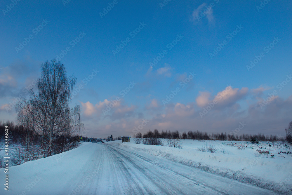 Russia. South Of Western Siberia. Picturesque cold sunset on a snow-covered road in The mountain Shoria. Russia. South Of Western Siberia. Picturesque cold sunset on a snow-covered road in The mountain Shoria.