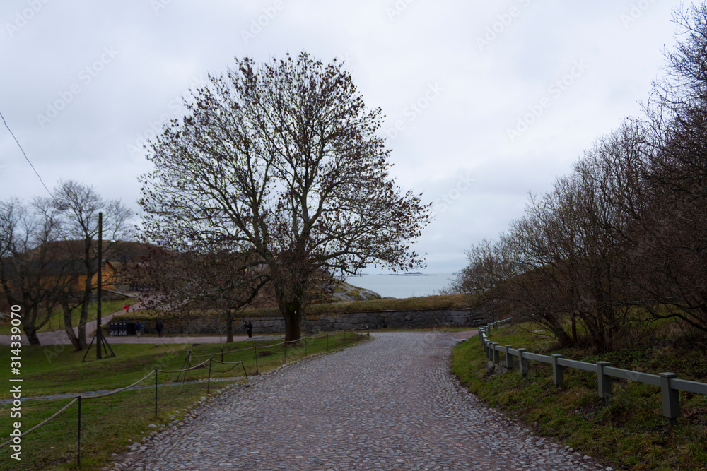 Old historic stone road to the bay on the Fort Suomenlinna island in Helsinki in Finland on an autumn day Old historic stone road to the bay on the Fort Suomenlinna island in Helsinki in Finland on an autumn day