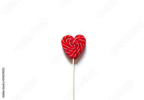 Heart shape red lollipop on the white background. Valentine's day greeting card