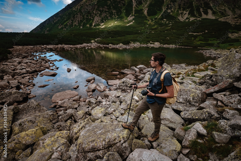 Man Traveler with backpack near mountain lake
