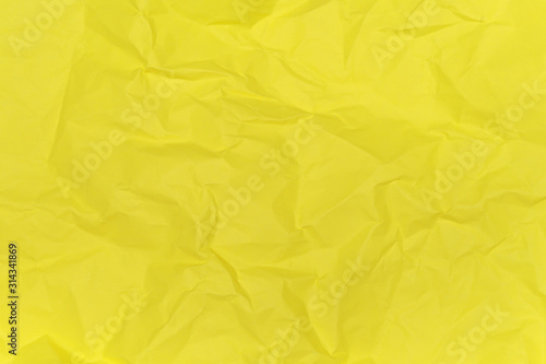 Crumpled paper texture background of yellow colour. View from above.
