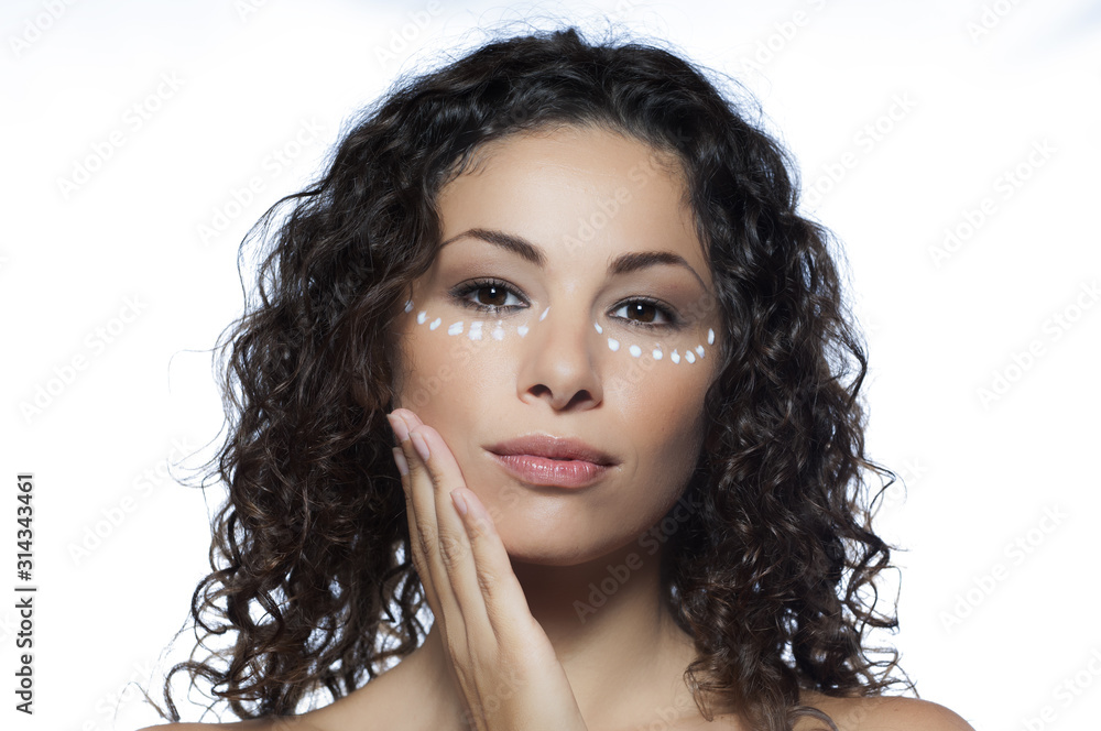 Ragazza con la crema sotto gli occhi si accarezza il viso Ragazza con la crema sotto gli occhi si accarezza il viso