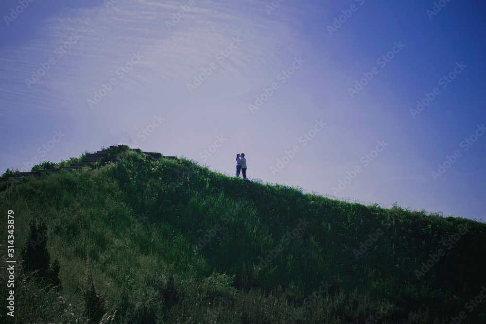 Silhouette of man and girl on the top of mountain