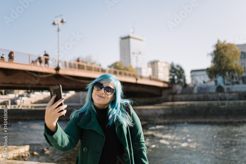 Solo tourist woman looking at phone and taking selfie
