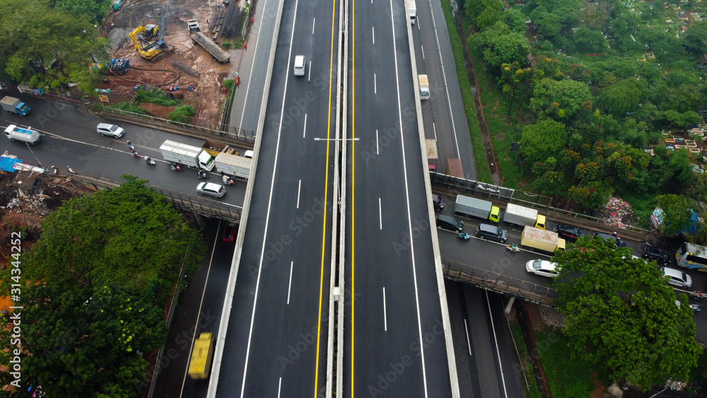 BEKASI, WESTJAVA, INDONESIA : JANUARY 10 202 : Aerial drone view of highway multilevel junction road with moving cars after rainy. Cars are blurred BEKASI, WESTJAVA, INDONESIA : JANUARY 10 202 : Aerial drone view of highway multilevel junction road with moving cars after rainy. Cars are blurred