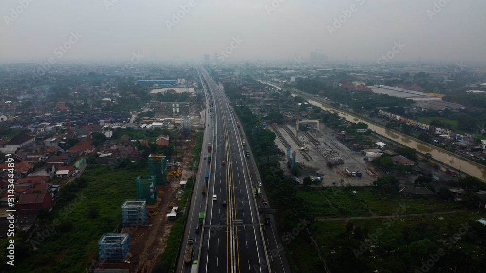 Obraz premium BEKASI, WESTJAVA, INDONESIA : JANUARY 10 202 : Aerial drone view of highway multilevel junction road with moving cars after rainy. Cars are blurred