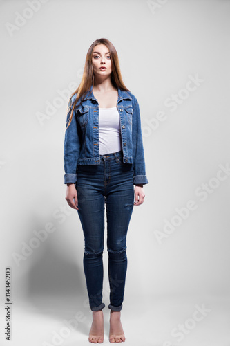 Young sexy woman in jeans jacket, white shirt jump