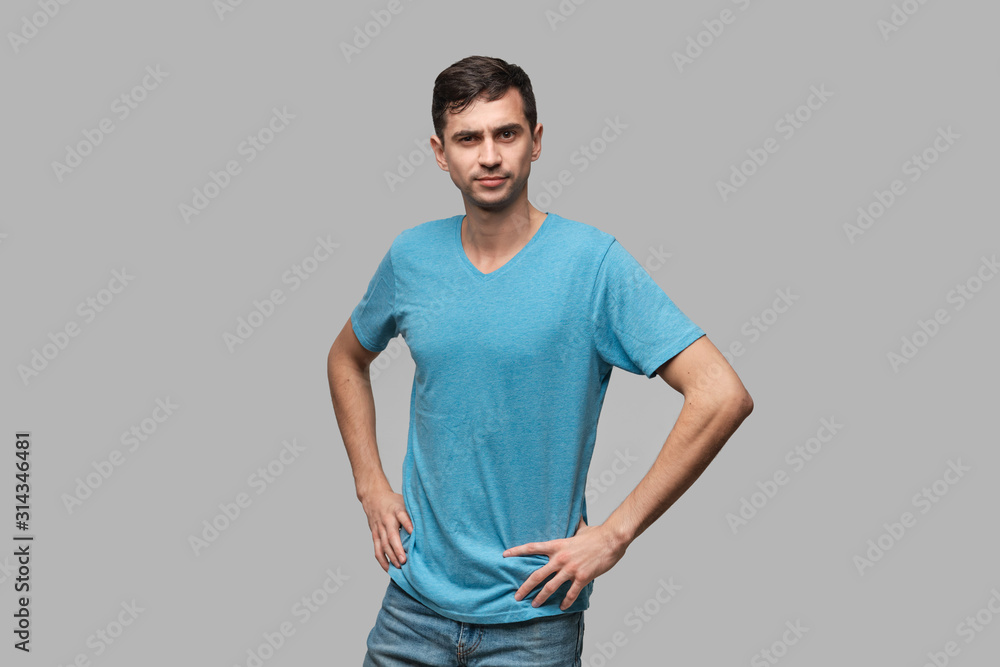 Confident man in a blue tee looking at the camera holding hands crossed. Concept of confidence Confident man in a blue tee looking at the camera holding hands crossed. Concept of confidence
