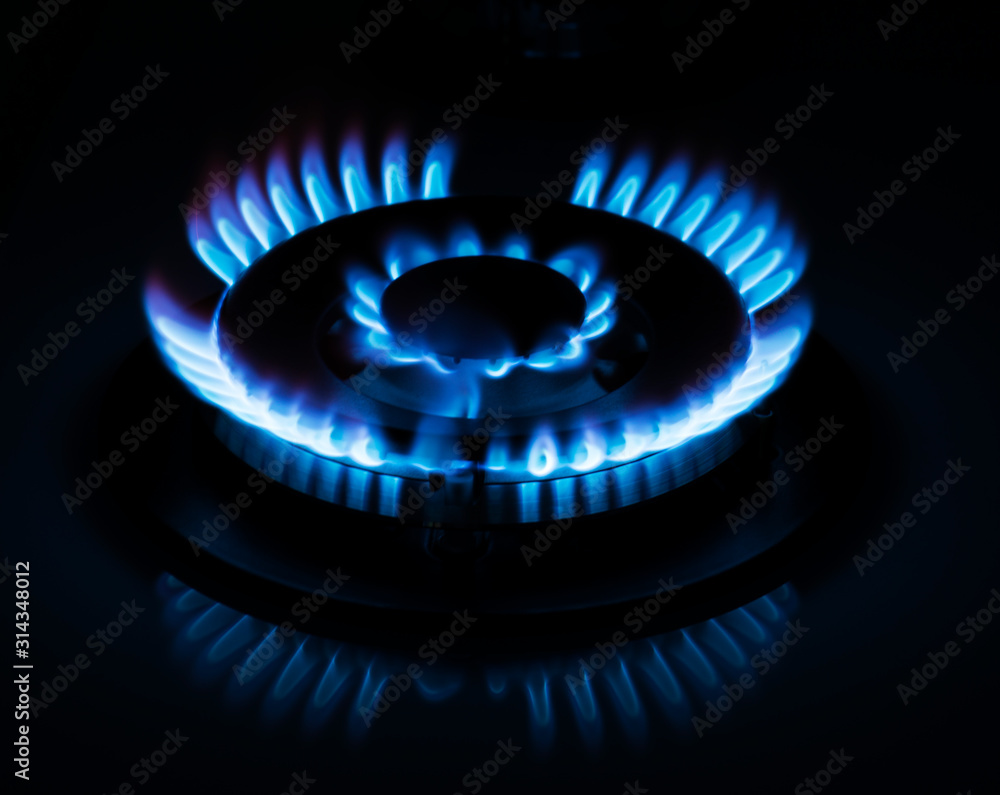 Natural gas burning on kitchen gas stove in the dark. Selective focus Natural gas burning on kitchen gas stove in the dark. Selective focus