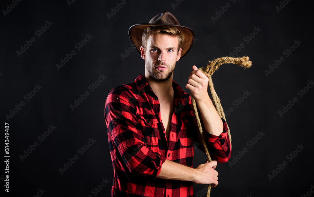 Fototapeta premium is he bandit. western cowboy portrait. man checkered shirt on ranch. Vintage style man. Wild West retro cowboy. cowboy with lasso rope. Western. wild west rodeo. man in hat black background