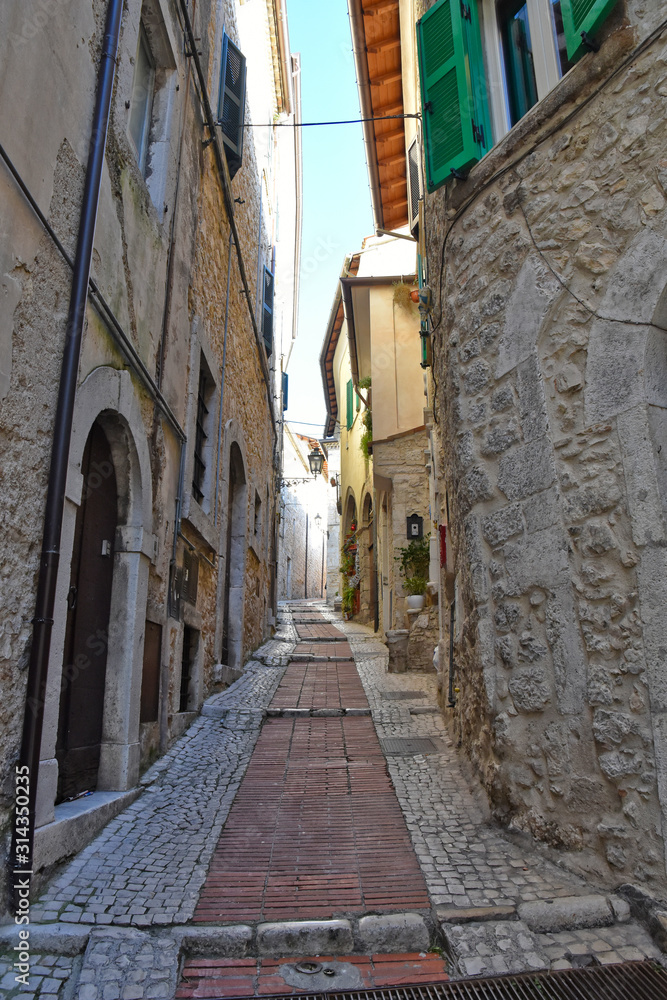 A narrow street between the old houses of a medieval town in Italy