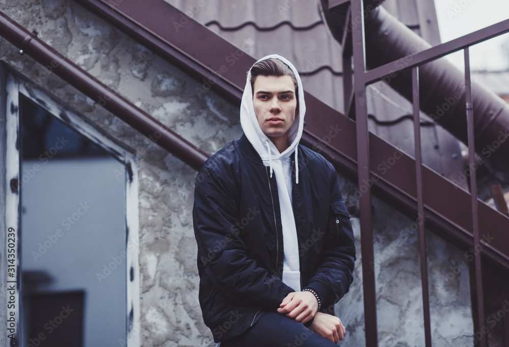trendy young man in black jacket posing in street trendy young man in black jacket posing in street