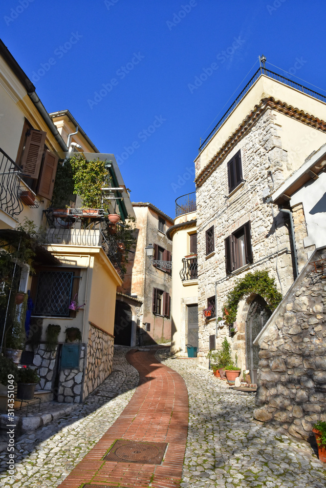 A narrow street between the old houses of a medieval town in Italy A narrow street between the old houses of a medieval town in Italy