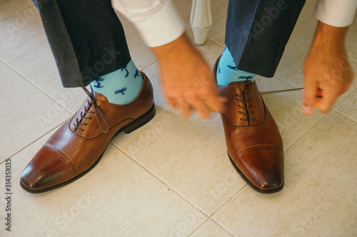 Groom putting his shoes on with socks