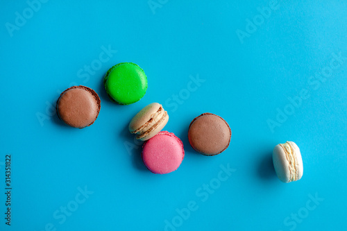 Colorful macarons on paper blue background.