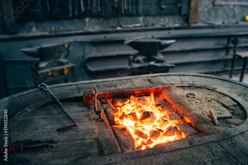 The hot furnace of the forge. Dark workshop of a blacksmith with an anvil  tools and a stove.