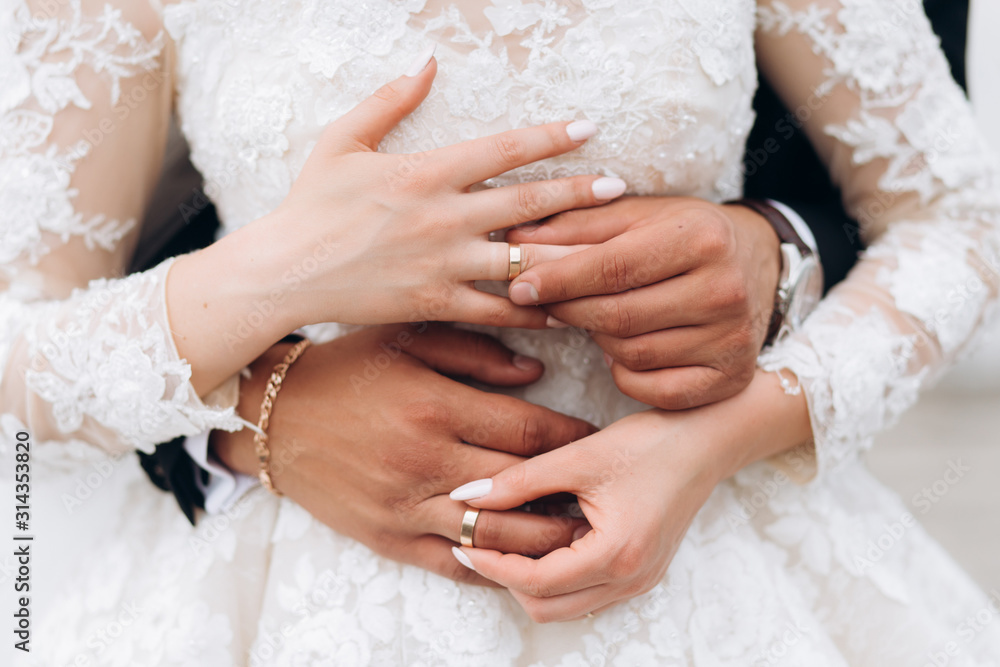 Groom and bride are putting on wedding rings, front view of hands Groom and bride are putting on wedding rings, front view of hands