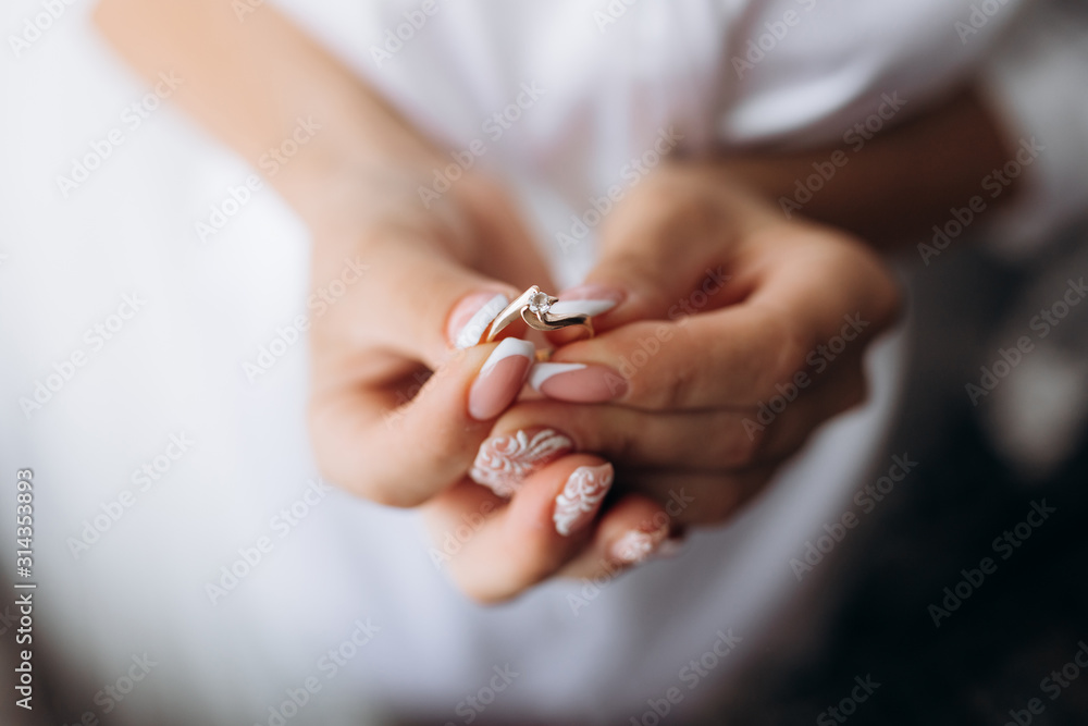 Bride is holding tender engagement ring in her hands Bride is holding tender engagement ring in her hands