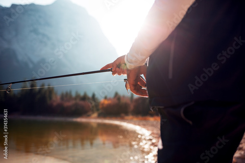 Unrecognizable fisherman holding fishing rod