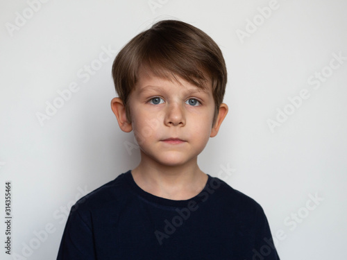 Portrait of a serious little boy on a white background