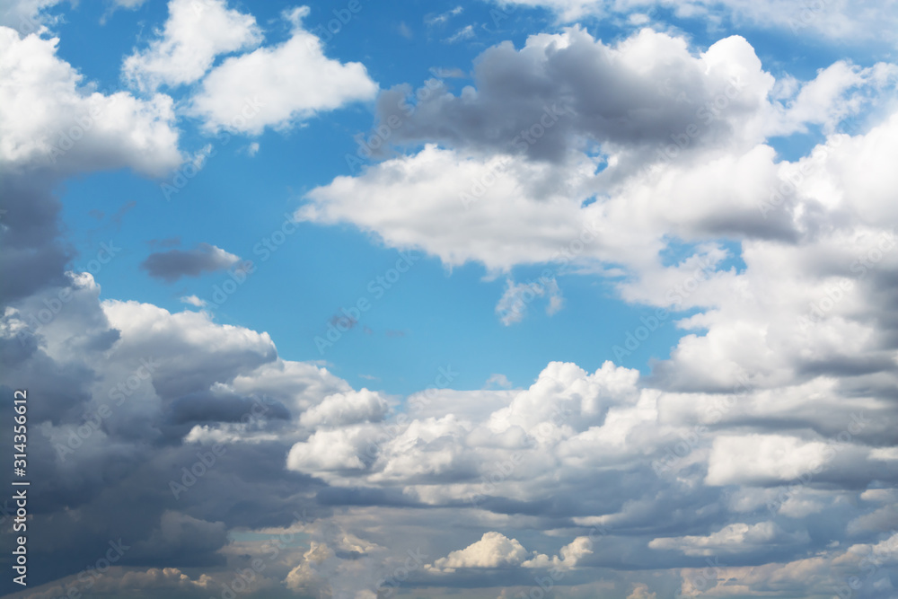Fototapeta premium White curly clouds in a blue sky. Sky background