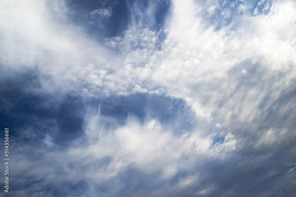 White curly clouds in a blue sky. Sky background