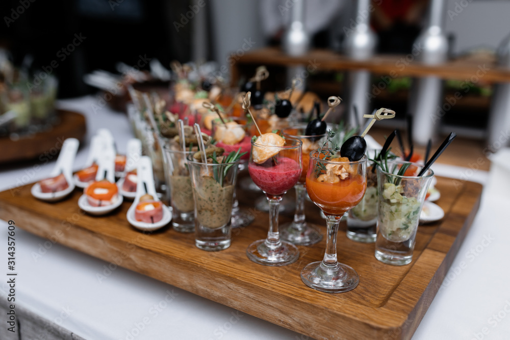 Fruit smoothies and snacks in glassware on the wooden tray