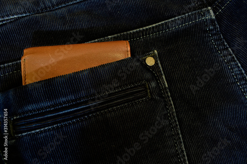 Brown wallet in the back pocket of blue jeans