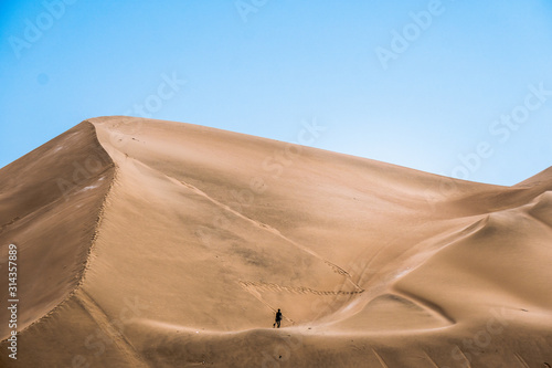 silhouette of man in the desert and big dunes in Peru.