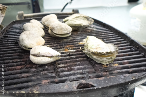 Grilled oysters on grill in the open air.