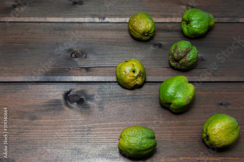 quince, trendy ugly chinese pear on a wooden dark background with place for text.