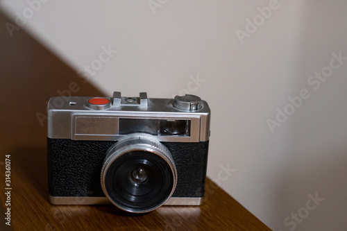 Vintage retro film 35mm camera on a wooden shelf