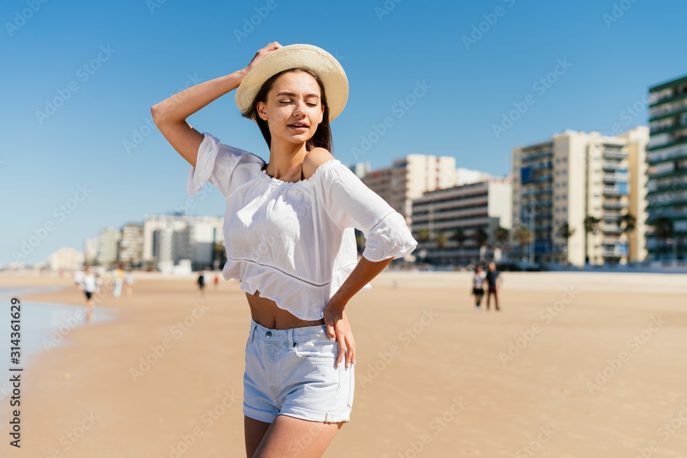 the girl theatrically closed her eyes and threw one hand behind her head, the other akimbo, setting her hip to the side. behind the beach and the building