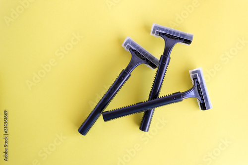 Set of disposable black razors on a yellow background