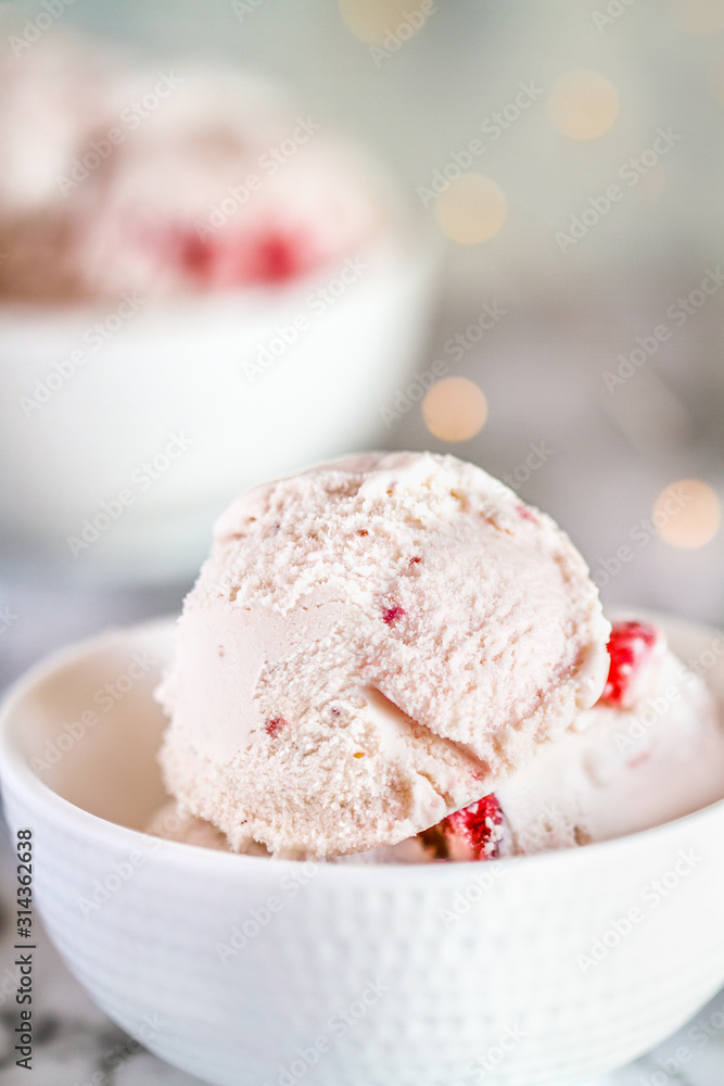 Strawberry ice cream with chunks of strawberries in a bowl. Selective focus with blurred background. Strawberry ice cream with chunks of strawberries in a bowl. Selective focus with blurred background.