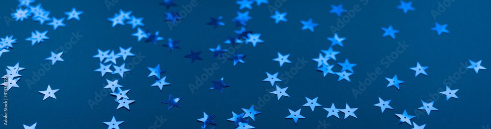 Stars confetti on classic blue background, close up, banner. Color 2020. Blue asterisks banner. Stars confetti on classic blue background, close up, banner. Color 2020. Blue asterisks banner.