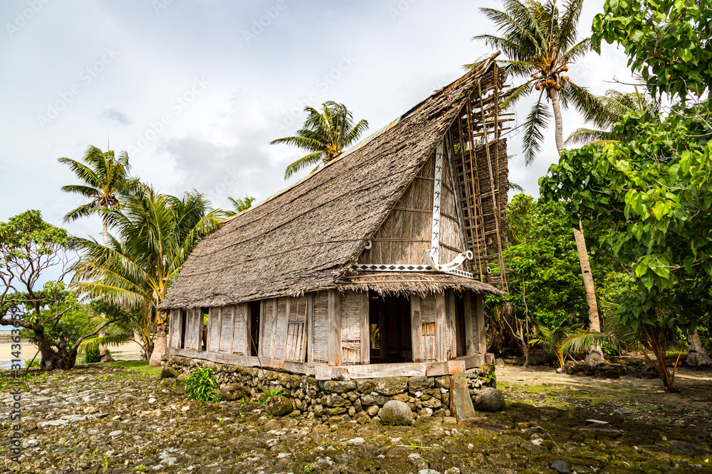 Old traditional thatched yapese men's meeting house faluw or fale, on an elevated limestone platform foundation. Shore of South Pacific ocean. Yap island, Federated States of Micronesia, Oceania Old traditional thatched yapese men's meeting house faluw or fale, on an elevated limestone platform foundation. Shore of South Pacific ocean. Yap island, Federated States of Micronesia, Oceania