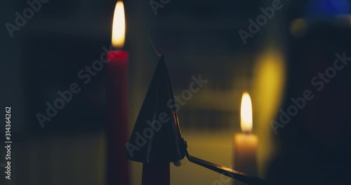Candles being extinguished by a snuffer photo