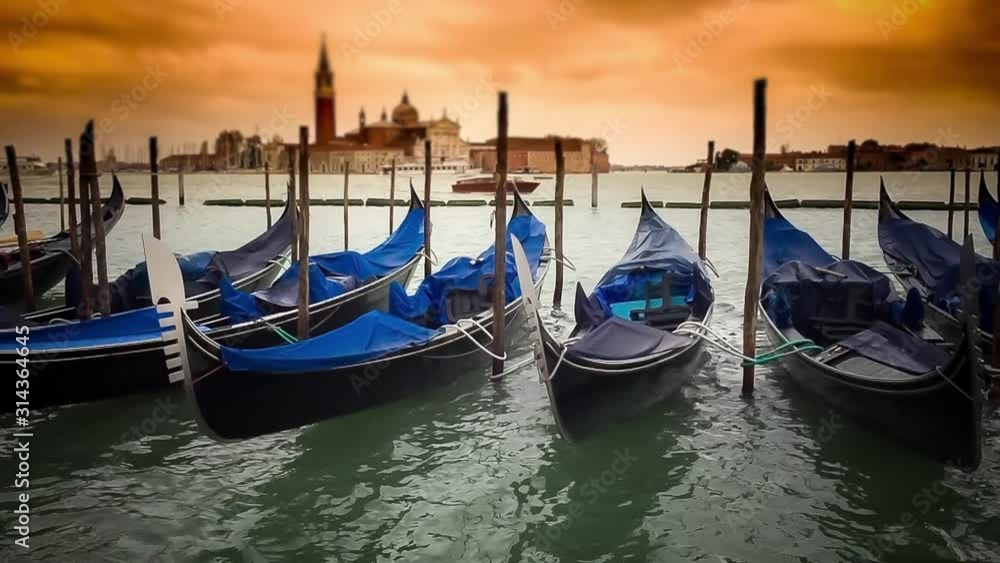 Empty gondolas in Venice moored with San Giorgio Maggiore church in the background at sunset Empty gondolas in Venice moored with San Giorgio Maggiore church in the background at sunset
