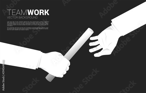 Close up hand passing baton in relay race between businessman. Business concept for teamwork and partnership