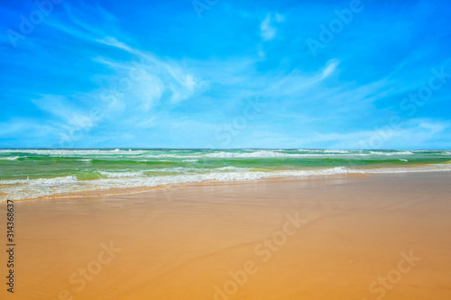 Small waves on turquoise sea. It is the Atlantic Ocean on the shores of West Africa. It is a beach near Dakar. In the background is a beautiful blue sky