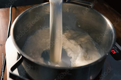 Pouring milk into the pan on scales.