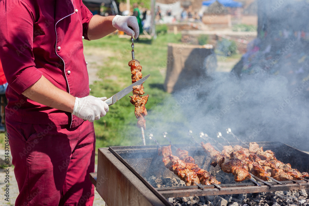 Fototapeta premium Grilling marinated meat on a grill. Street food festival